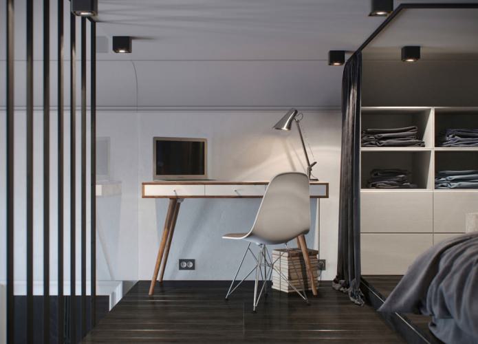 Schlafzimmerinnenraum mit Arbeitsplatz in einem Studio-Apartment mit hohen Decken