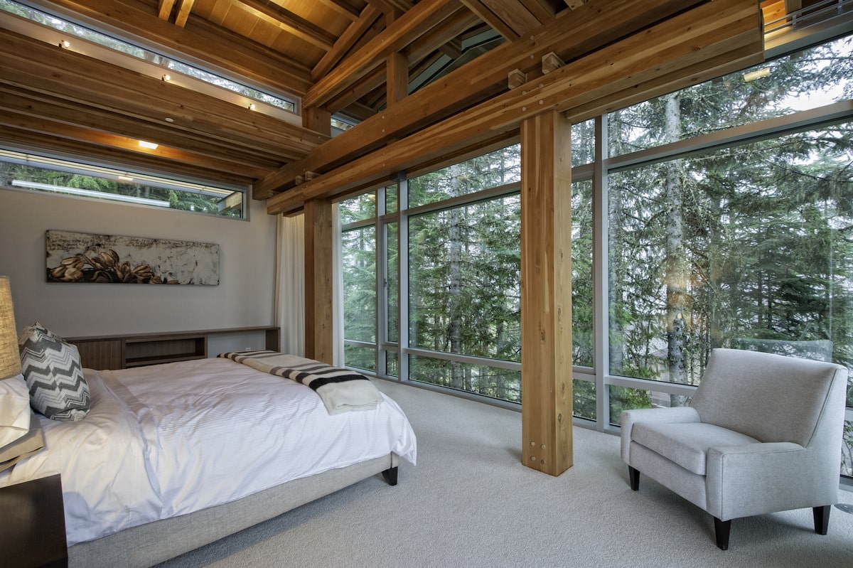 Унутрашњост спаваће собе у сеоској кући са панорамским прозорима