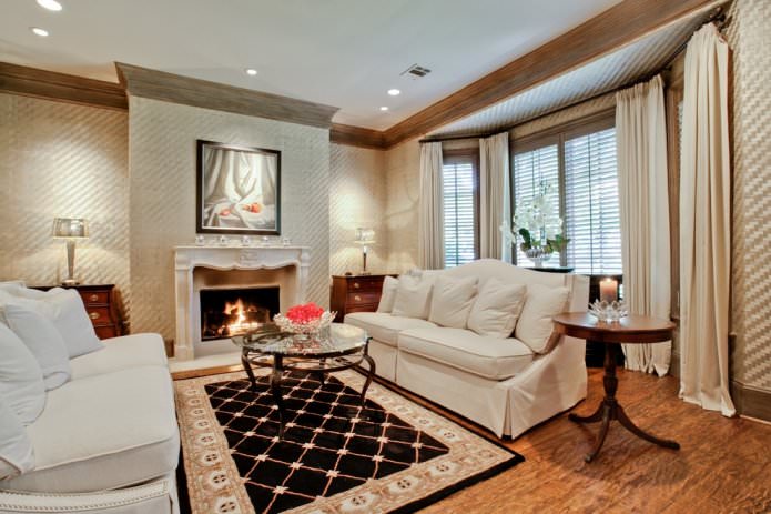 Beige wallpaper in the interior of a living room with a fireplace
