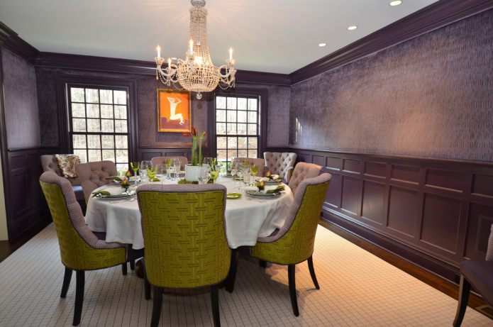ห้องทานอาหารพร้อมวอลเปเปอร์สีม่วงเข้มและเก้าอี้สีเขียวม่วง