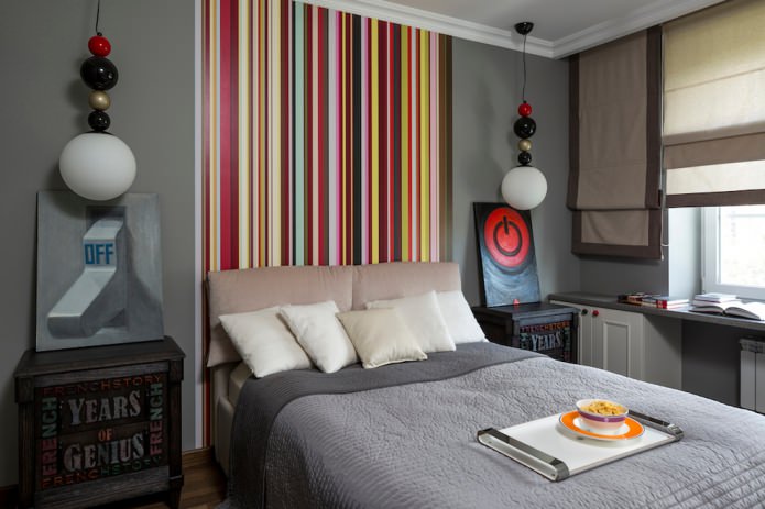 mehrfarbig gestreifte Wand am Kopfende des Bettes