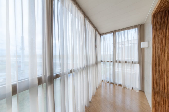 curtains of white color in the interior of the balcony