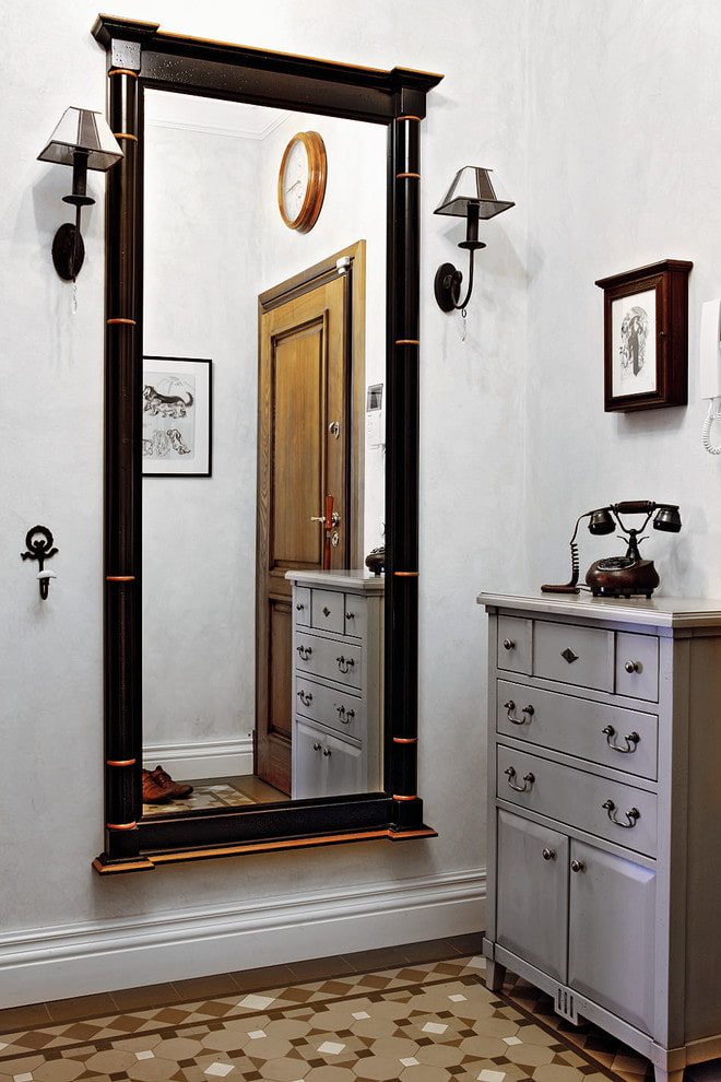 mirror with sconces in the interior of the hallway