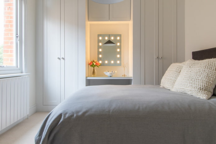 mirror with bulbs around the perimeter in the bedroom