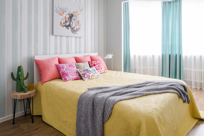 Bett mit gelber Tagesdecke im Schlafzimmer
