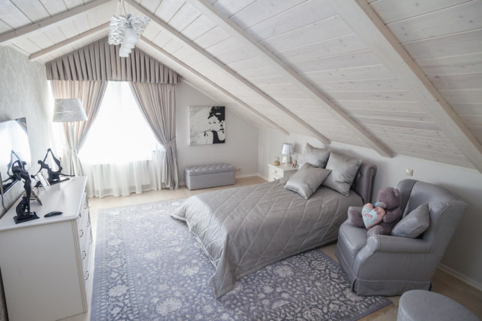 Bett mit grauer Tagesdecke im Schlafzimmer