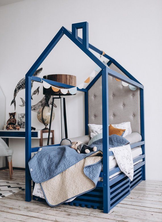 blaues Bett in Form eines Hauses im Kinderzimmer