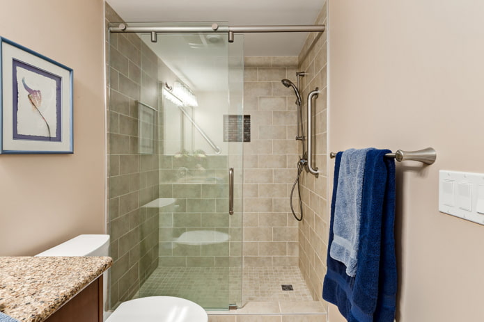 Duschbad aus beigefarbenen Fliesen im Innenraum