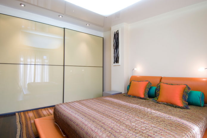 Kleiderschrank mit glänzender Fassade im Inneren des Schlafzimmers