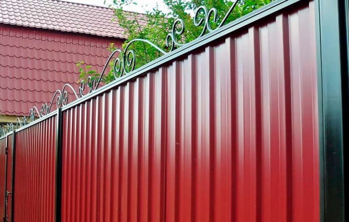 Црвена ограда од профилисаног лима са ковачким елементима