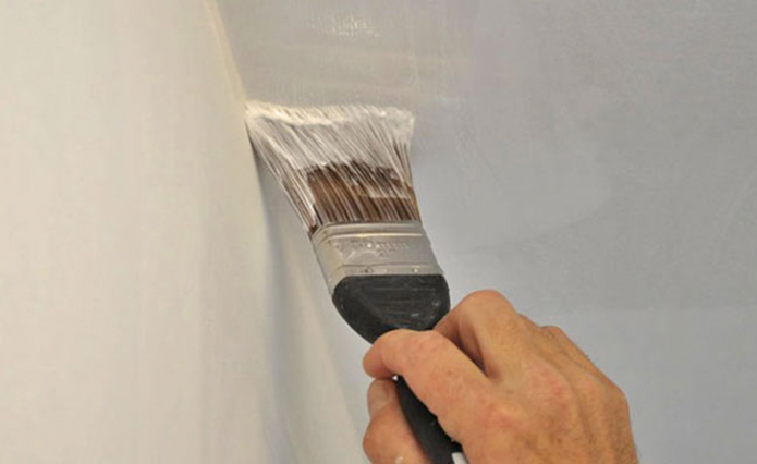 Painting the joints of the ceiling and walls with a brush