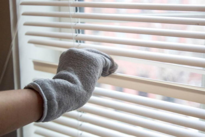 Cleaning the blinds with a toe