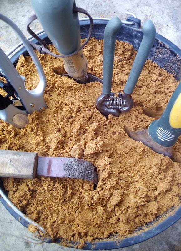 Werkzeuge in einem Eimer Sand