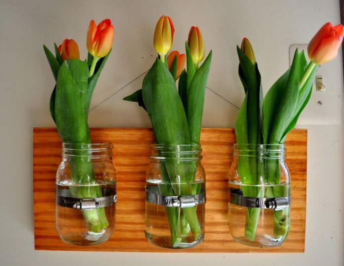 a combination of homemade flower vases from jars