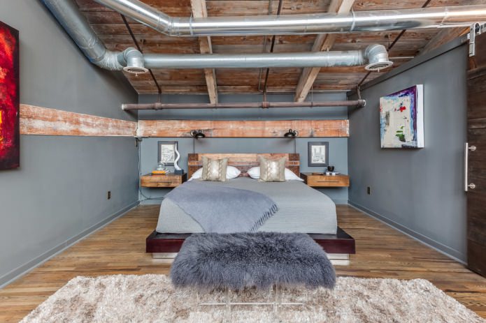 Decke mit Industrierohren und Holzbalken, rohe Bretter an den Wänden