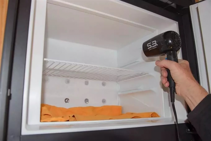 Abtauen des Kühlschranks mit einem Fön