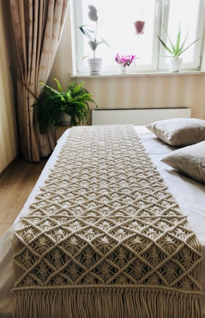 a blanket on a macrame bed