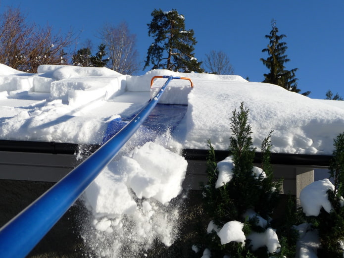 Cleaning snow with a scraper