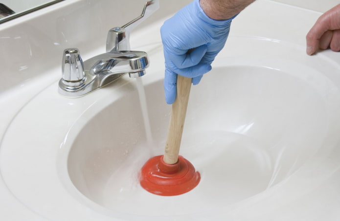 cleaning the blockage with a plunger