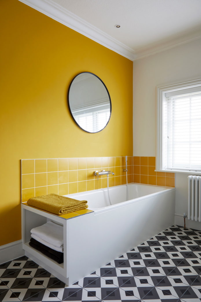 ห้องน้ำที่มีผนังสีเหลืองและพื้นกระเบื้องโมเสคสีดำและสีขาว