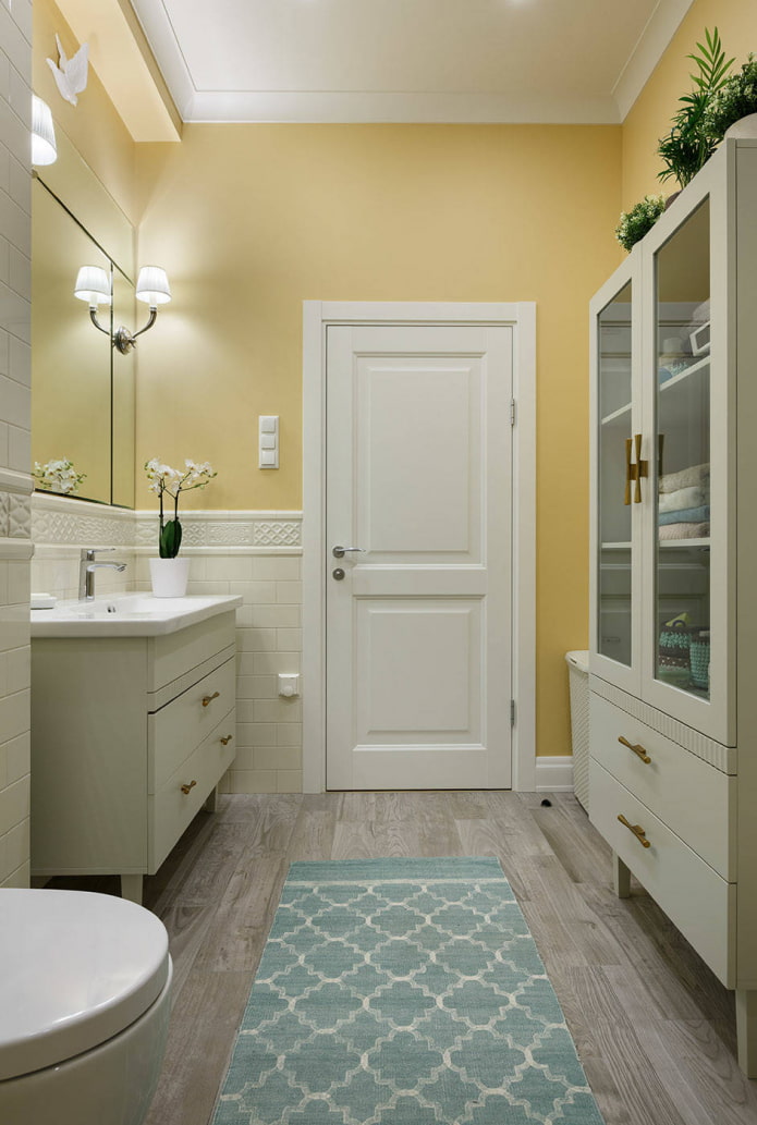 fürdőszoba halványsárga falakkal és fehér bútorokkal
