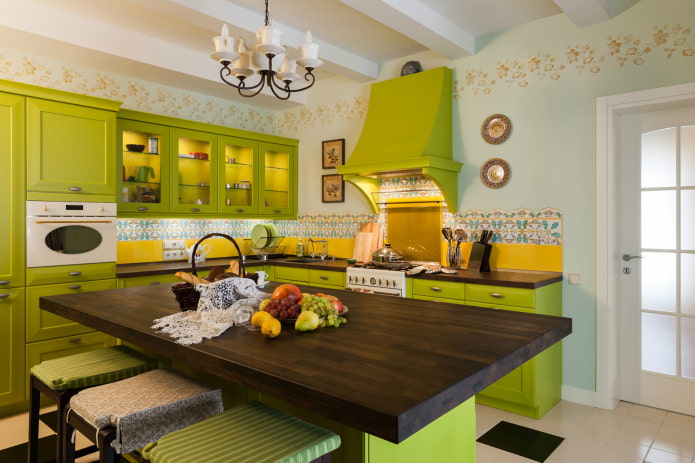 ห้องครัวพร้อมชุดเฟอร์นิเจอร์สีเขียวอ่อนและผ้ากันเปื้อนสีเหลือง