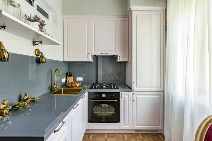 small kitchen with white furniture, gray countertops and an apron of the same material