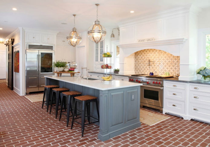 the floor in the gray and white kitchen in the form of red brickwork